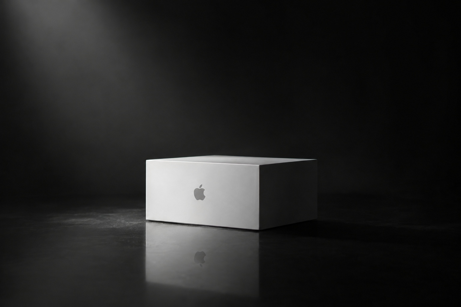A plain white laptop-sized product box on a smooth gray studio background