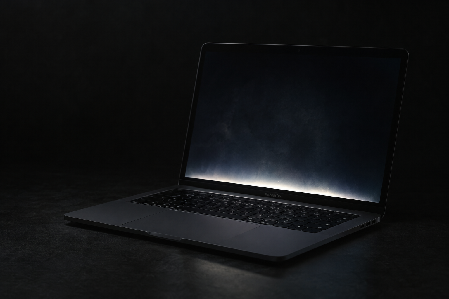 Close-up of the bottom edge of a dark laptop display showing an uneven bright glow suggesting a backlight defect