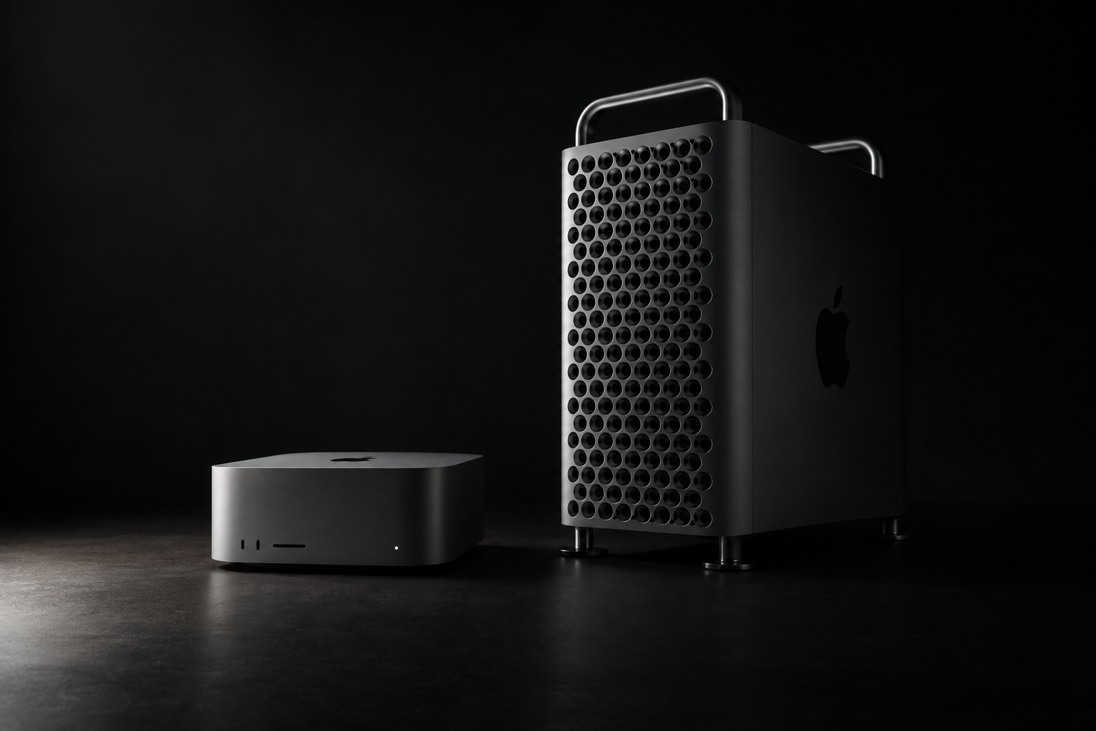 A small square desktop computer next to a tall tower computer on a gray studio surface
