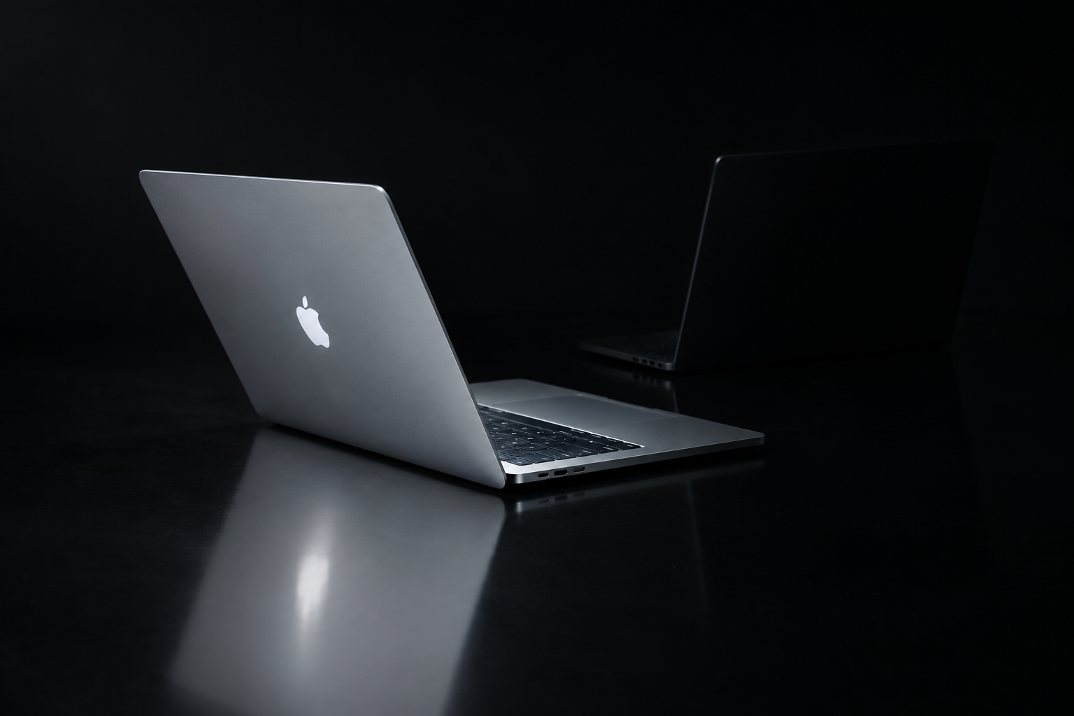 A closed aluminum laptop photographed at an angle on a smooth gray background