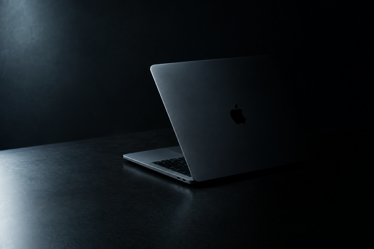 A thin closed laptop photographed on a two-tone gray background